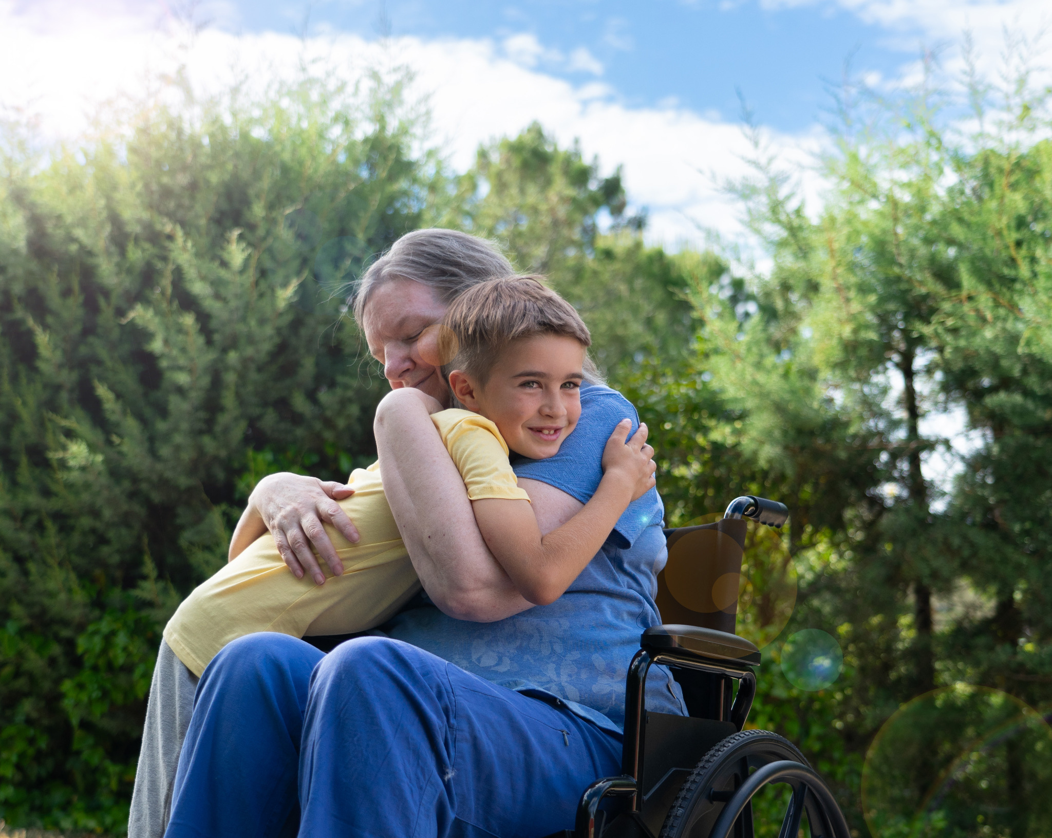 Young boy hugging an older family member outdoors