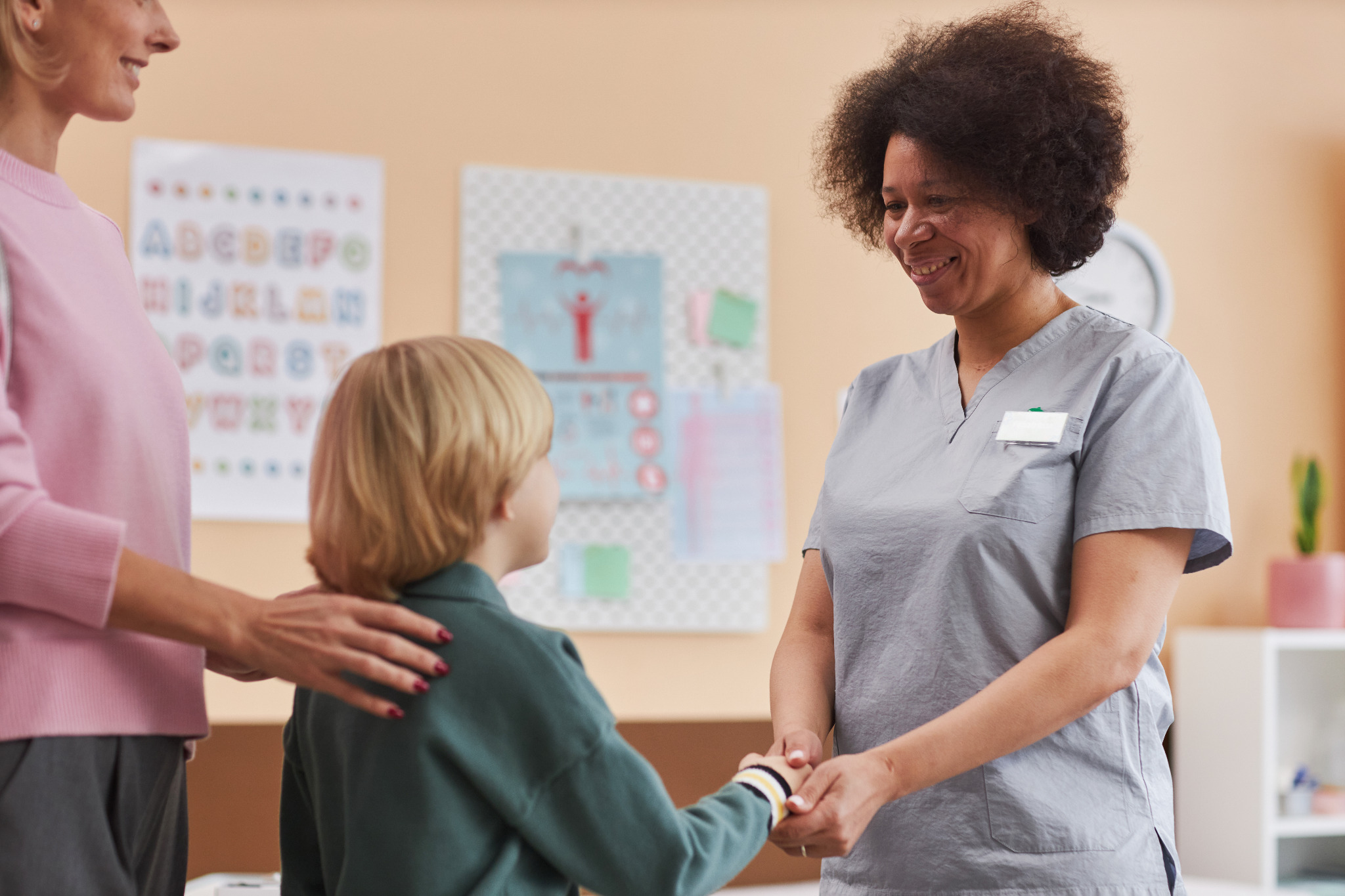 Care professional holding hands with a child in a clinic